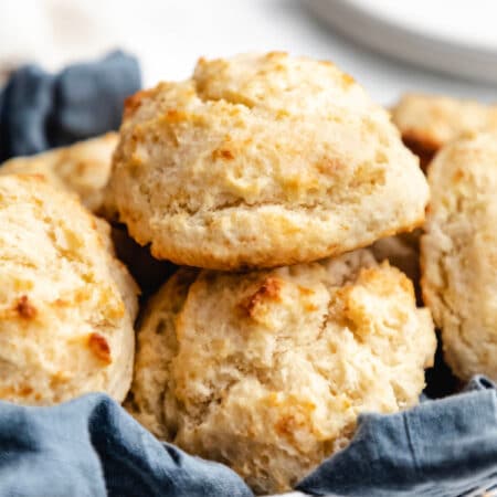 A basket of buttermilk drop biscuits lined with a blue linen.