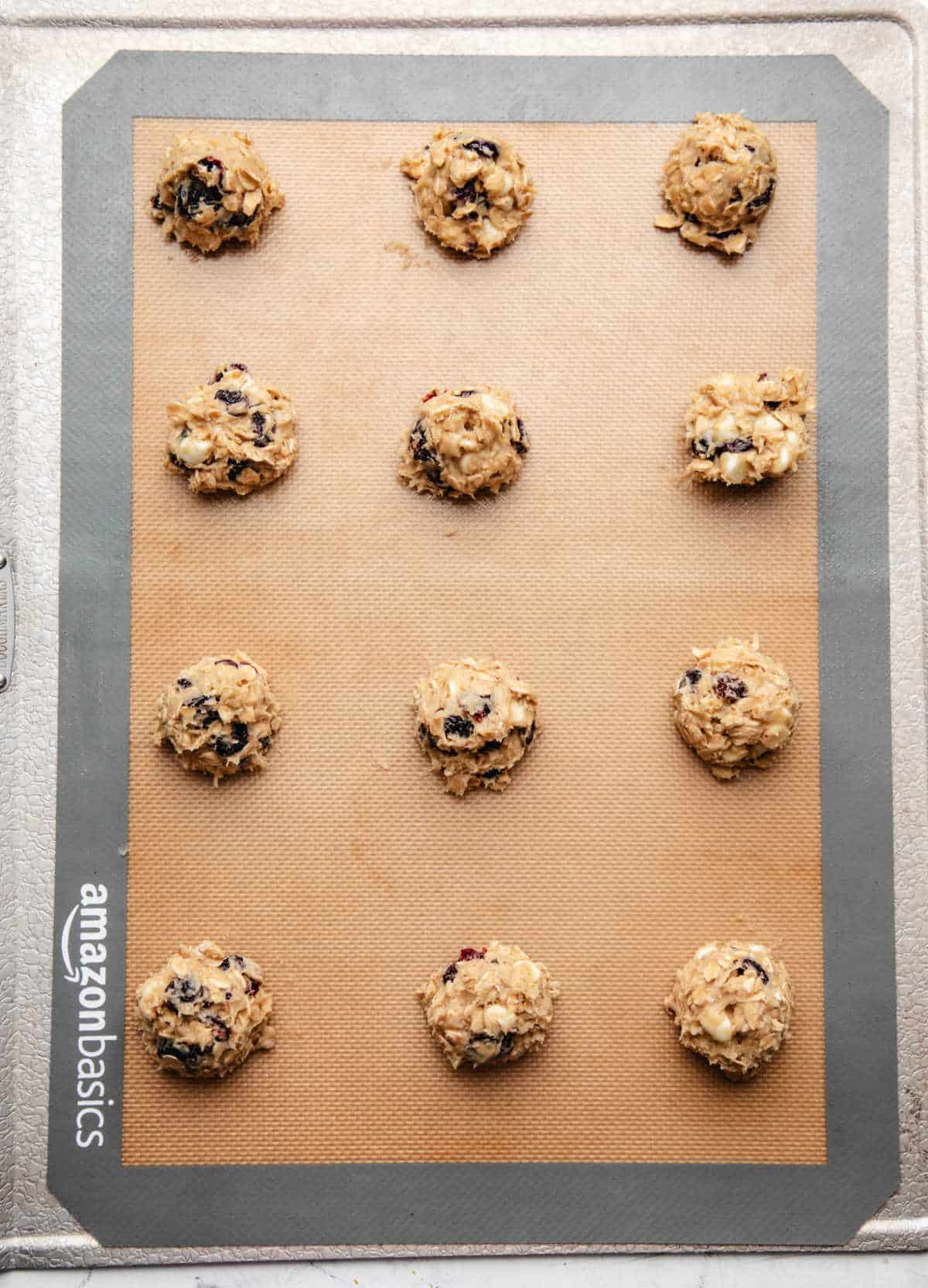 Cranberry oatmeal cookie dough on a prepared baking sheet.