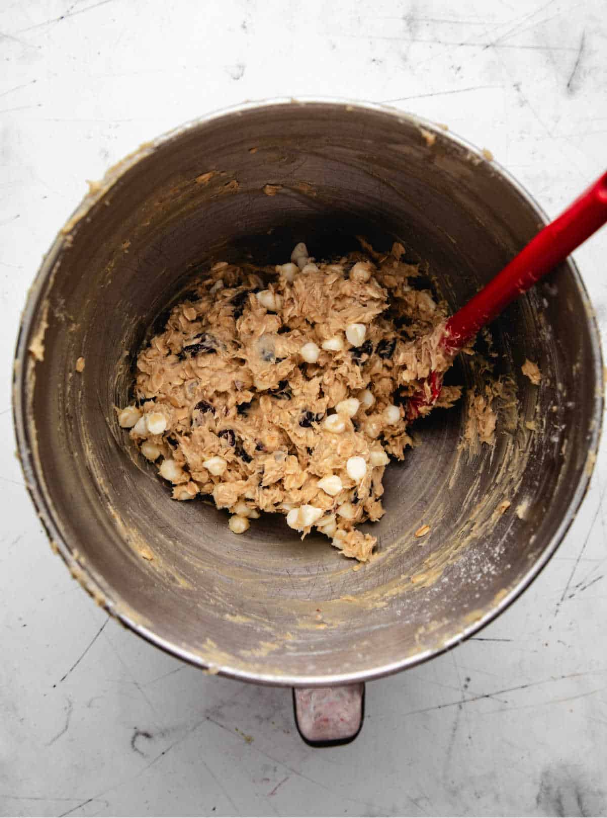 Dried cranberries and white chocolate chips stirred into oatmeal cookie dough.
