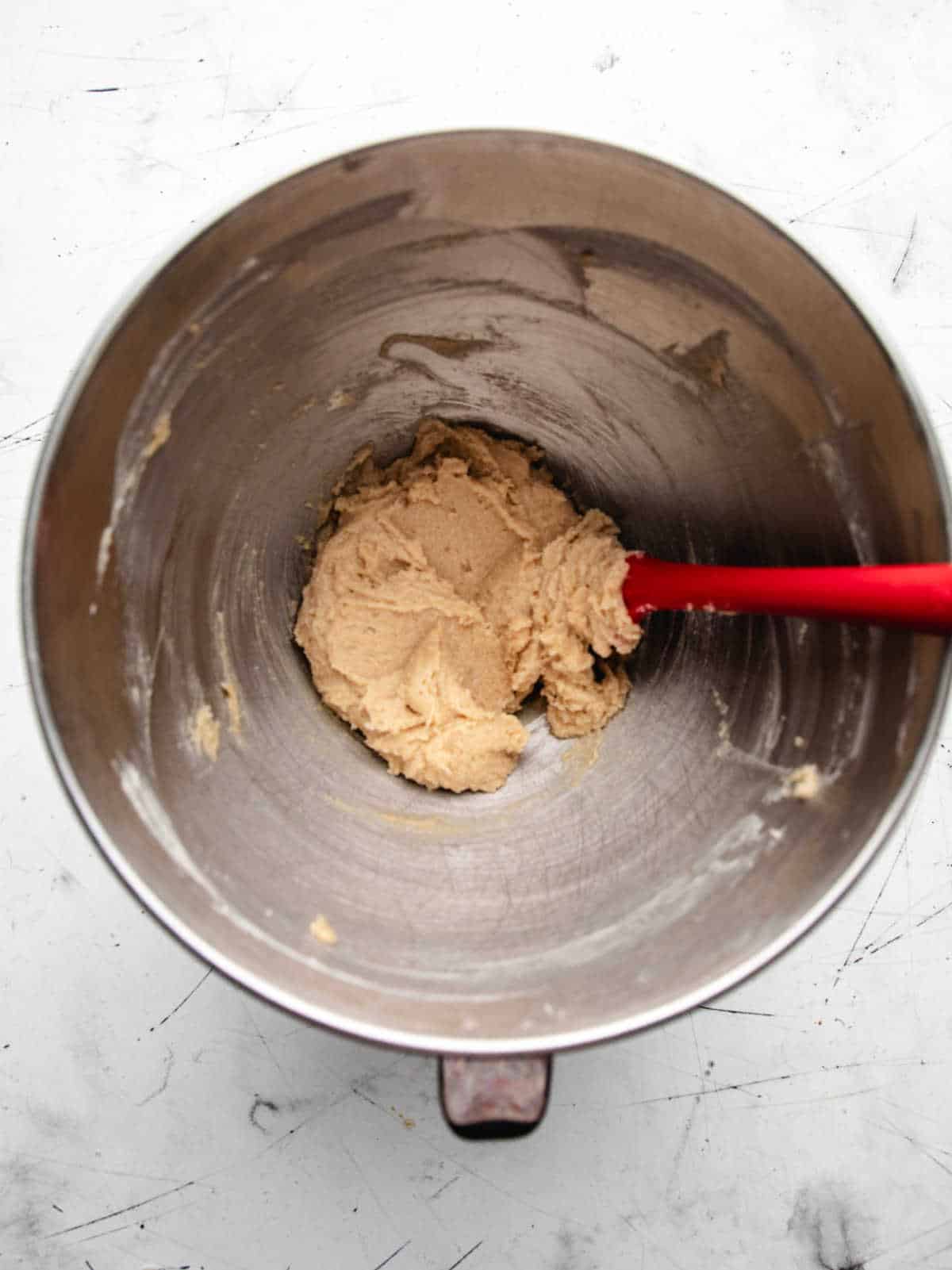 Creamed butter and sugar mixture in a silver mixing bowl. 