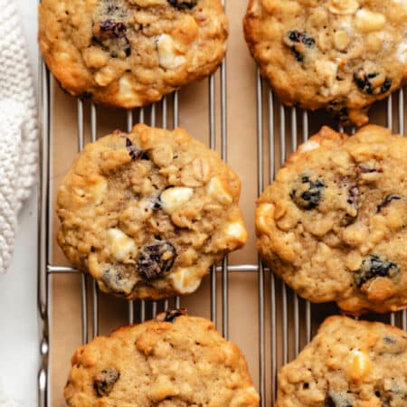 Two rows of cranberry oatmeal cookies on a wire cooling rack.