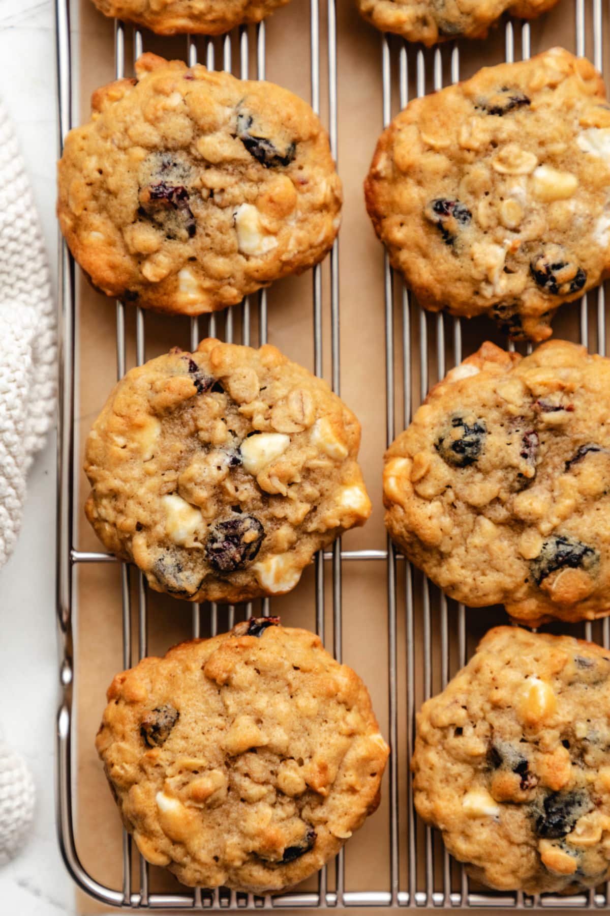 Two rows of cranberry oatmeal cookies on a wire cooling rack.