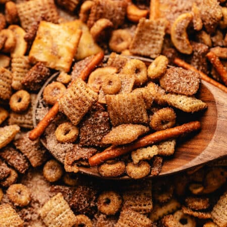 A wooden spoon holding a scoop of Sweet and Salty Chex Mix.