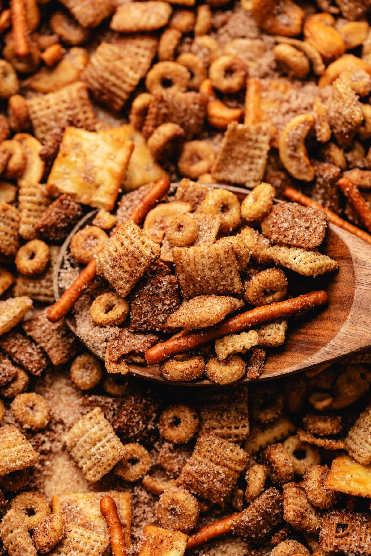 A wooden spoon holding a scoop of Sweet and Salty Chex Mix.