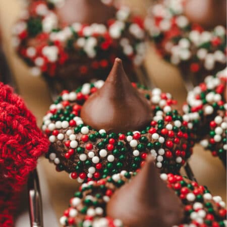 A row of Christmas kiss cookies on a wire cooling rack.