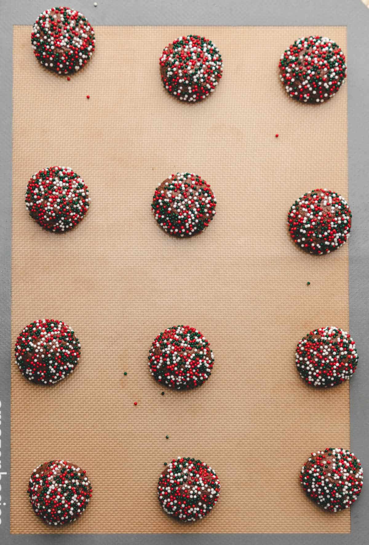 Baked chocolate sprinkle cookies on a baking sheet. 
