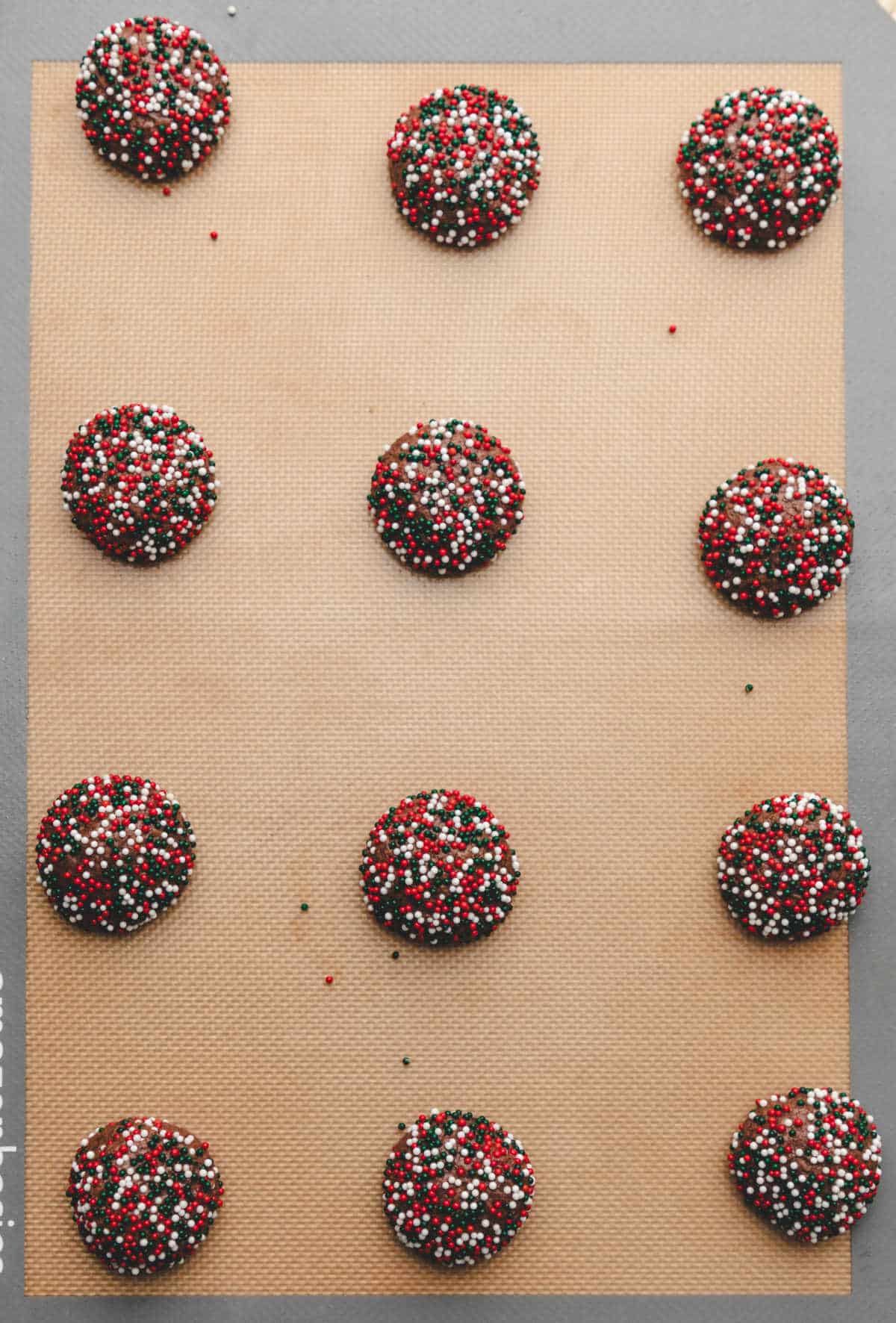 Baked chocolate sprinkle cookies on a baking sheet.