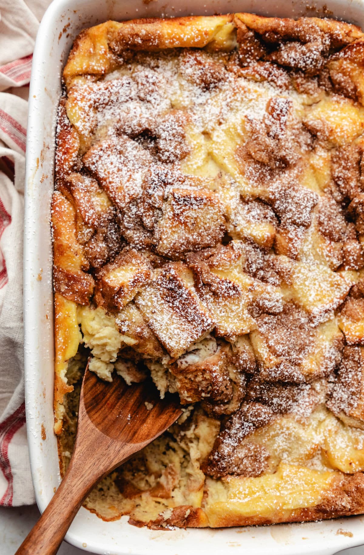 A baked French toast casserole dusted with powdered sugar. 