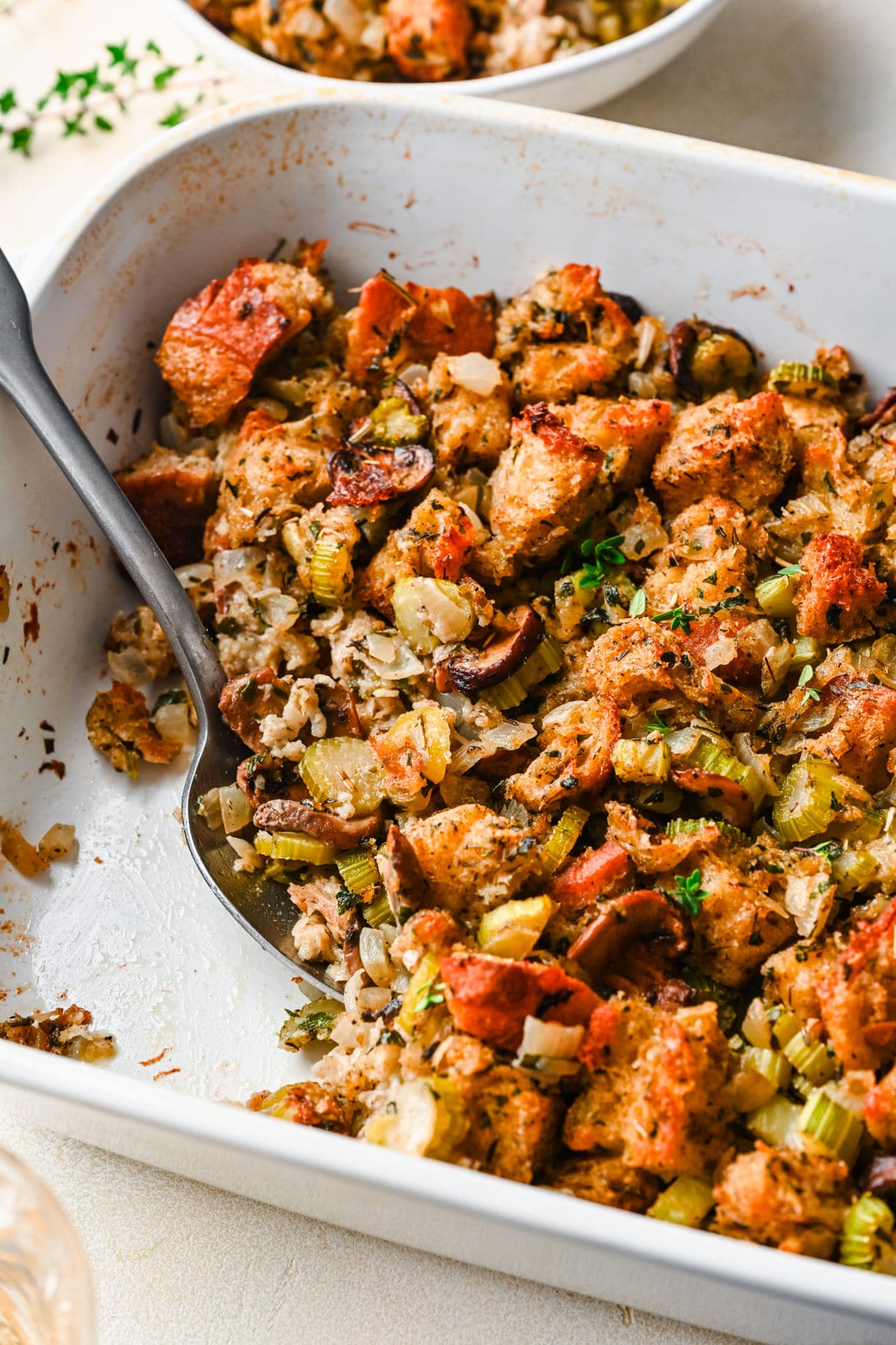 A silver spoon in a white dish of homemade stuffing.