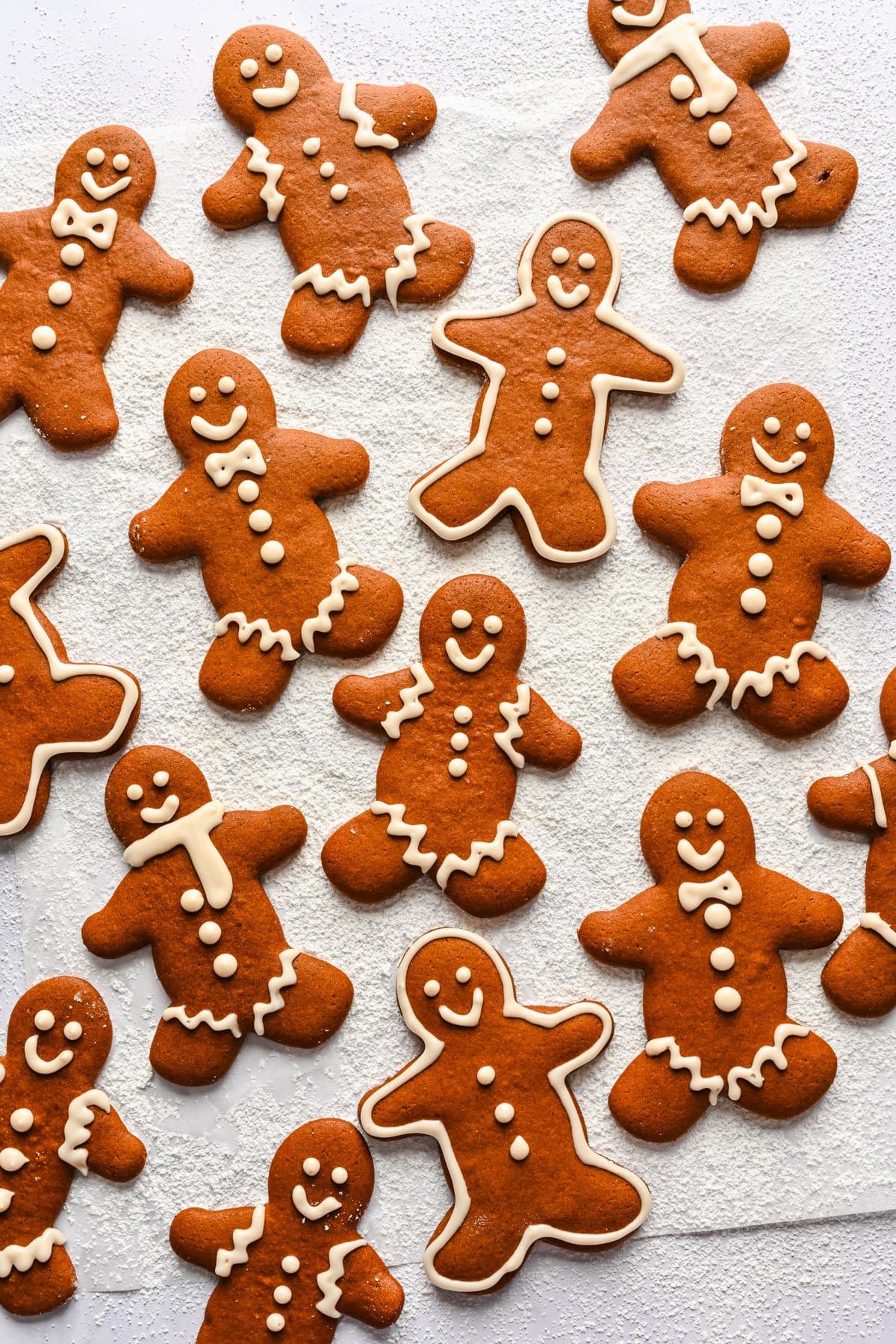 Several decorated no chill gingerbread men on a piece of parchment paper. 