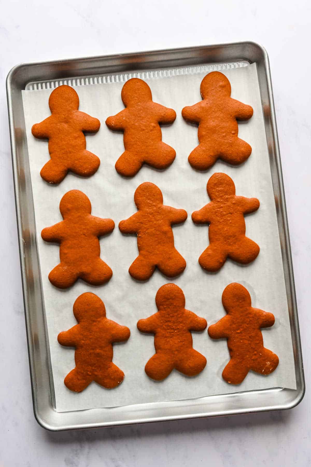 Baked gingerbread men on a baking sheet.