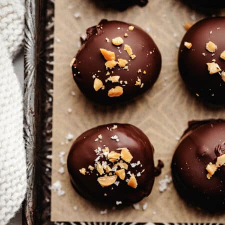 Rows of peanut butter Oreo cookie balls on piece of brown parchment paper.