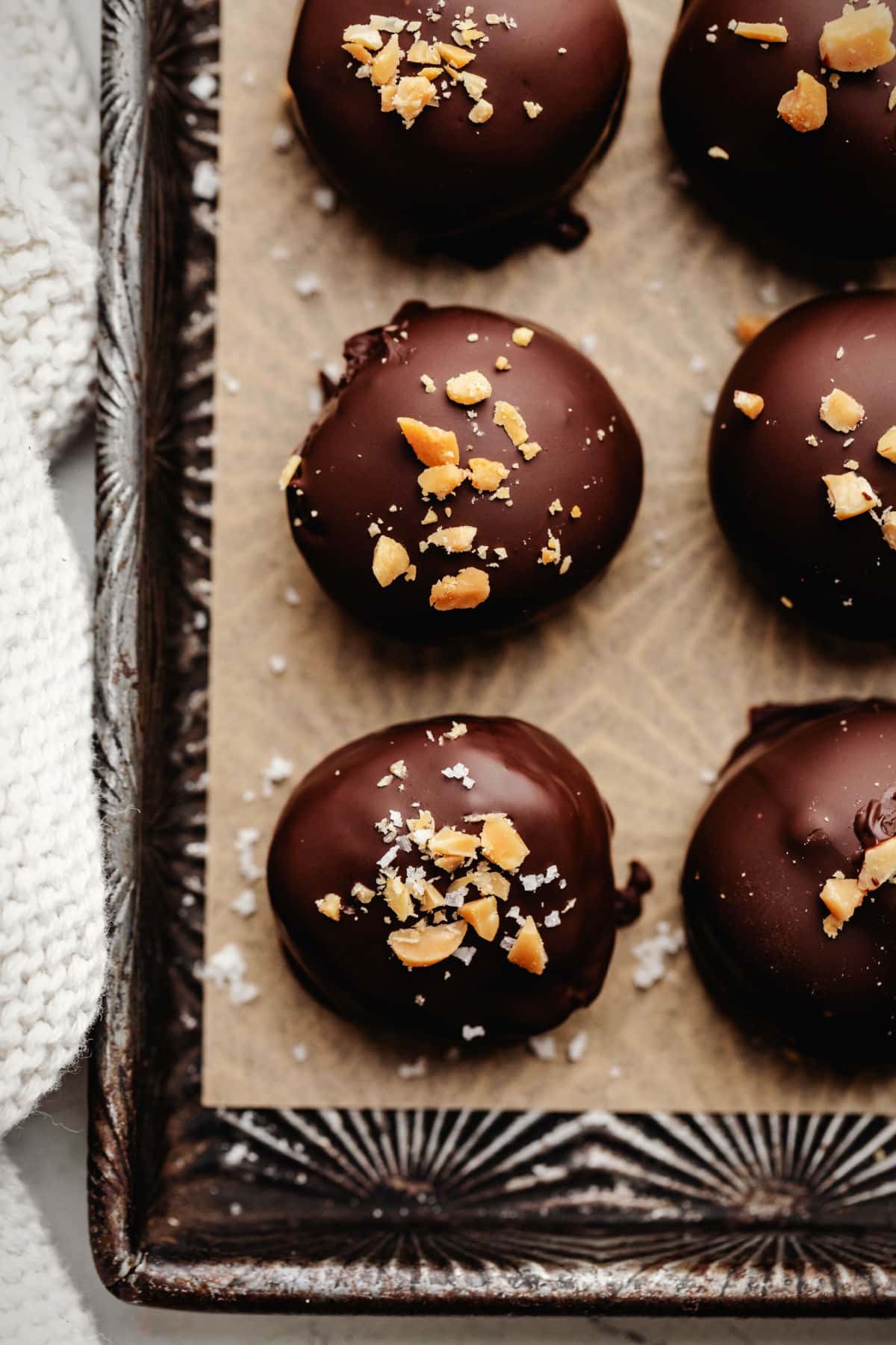 Rows of peanut butter Oreo cookie balls on piece of brown parchment paper.