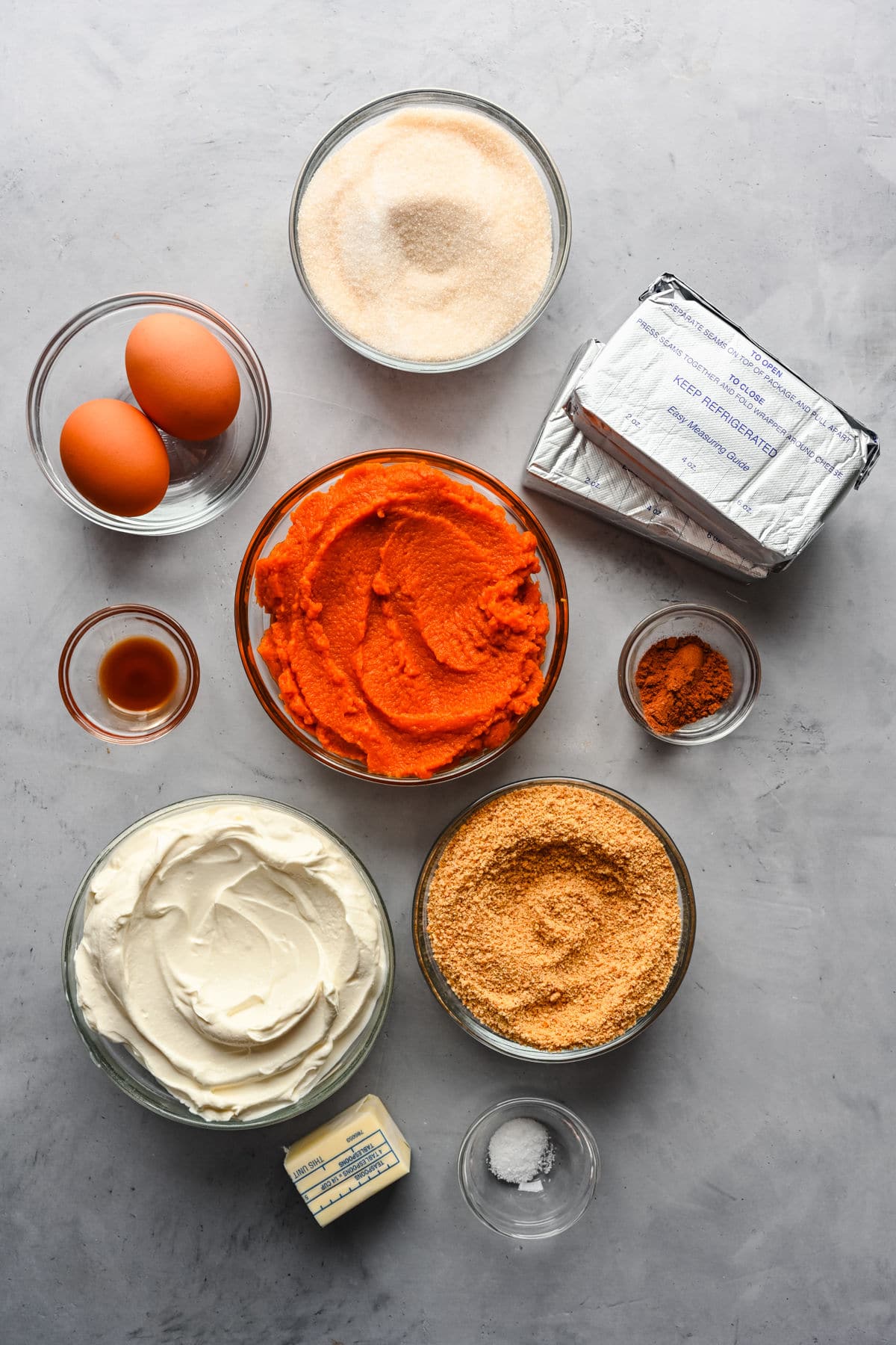 Ingredients for pumpkin cheesecake in dishes.