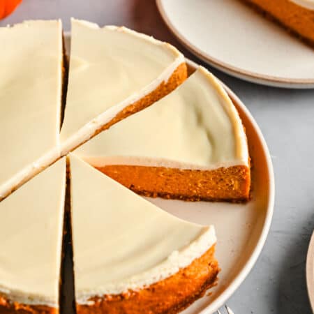 Slices of pumpkin cheesecake cut from the cheesecake on a platter.