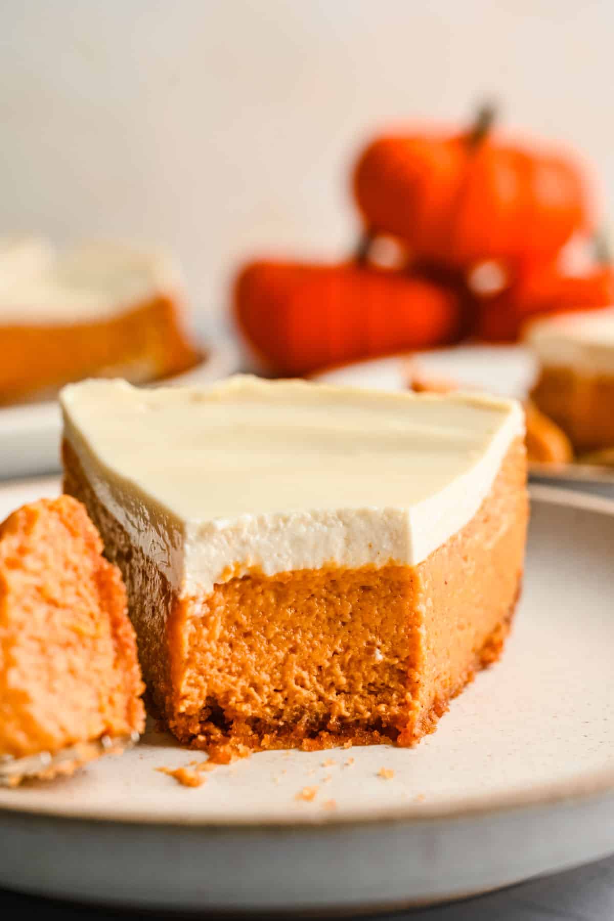 A slice of pumpkin cheesecake with a bite on the fork next to it.