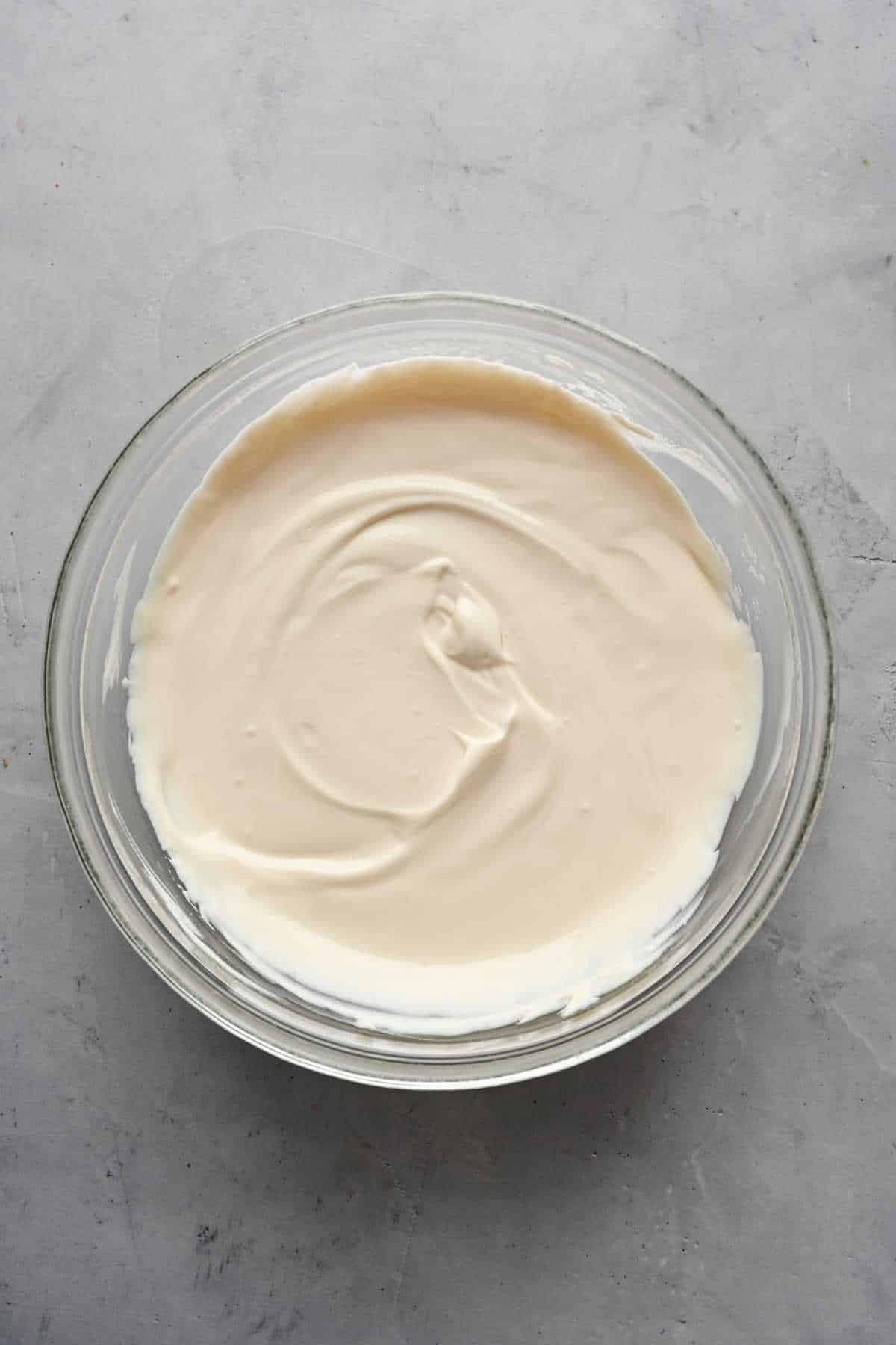 Sour cream mixture in a glass mixing bowl. 