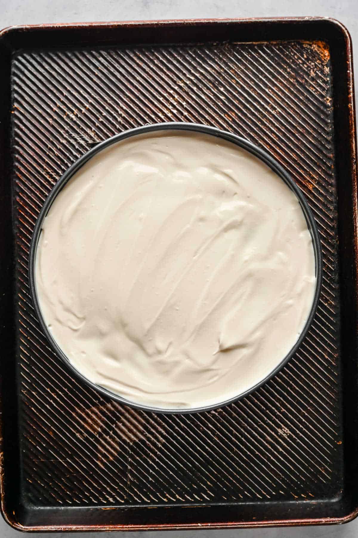 Cream cheese mixture spread over a pumpkin cheesecake.