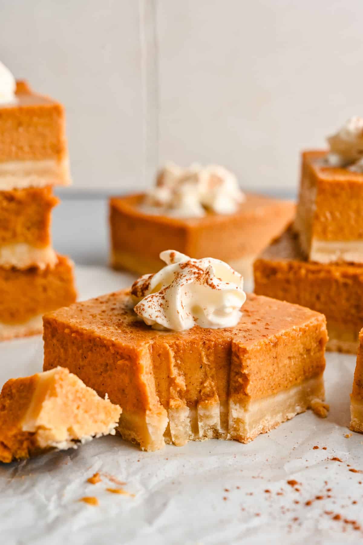 A pumpkin pie bar with a bite on a fork next to the bar. 