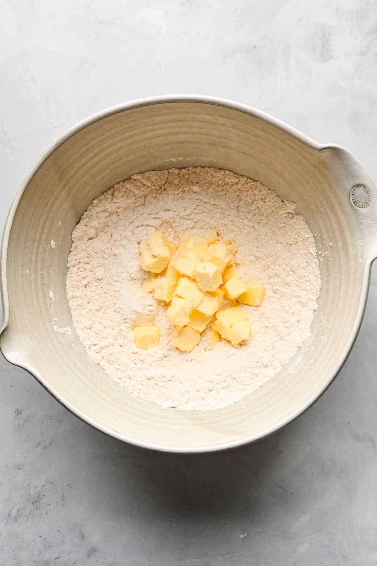 Butter and dry ingredients for the pumpkin pie bar crust in a mixing bowl.