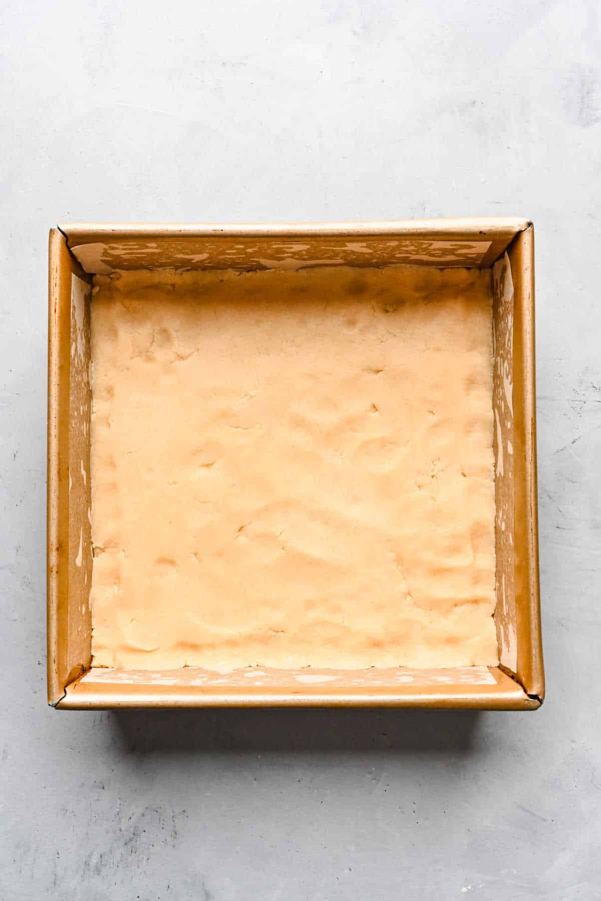 Pumpkin pie bar crust dough in the bottom of a baking tin.