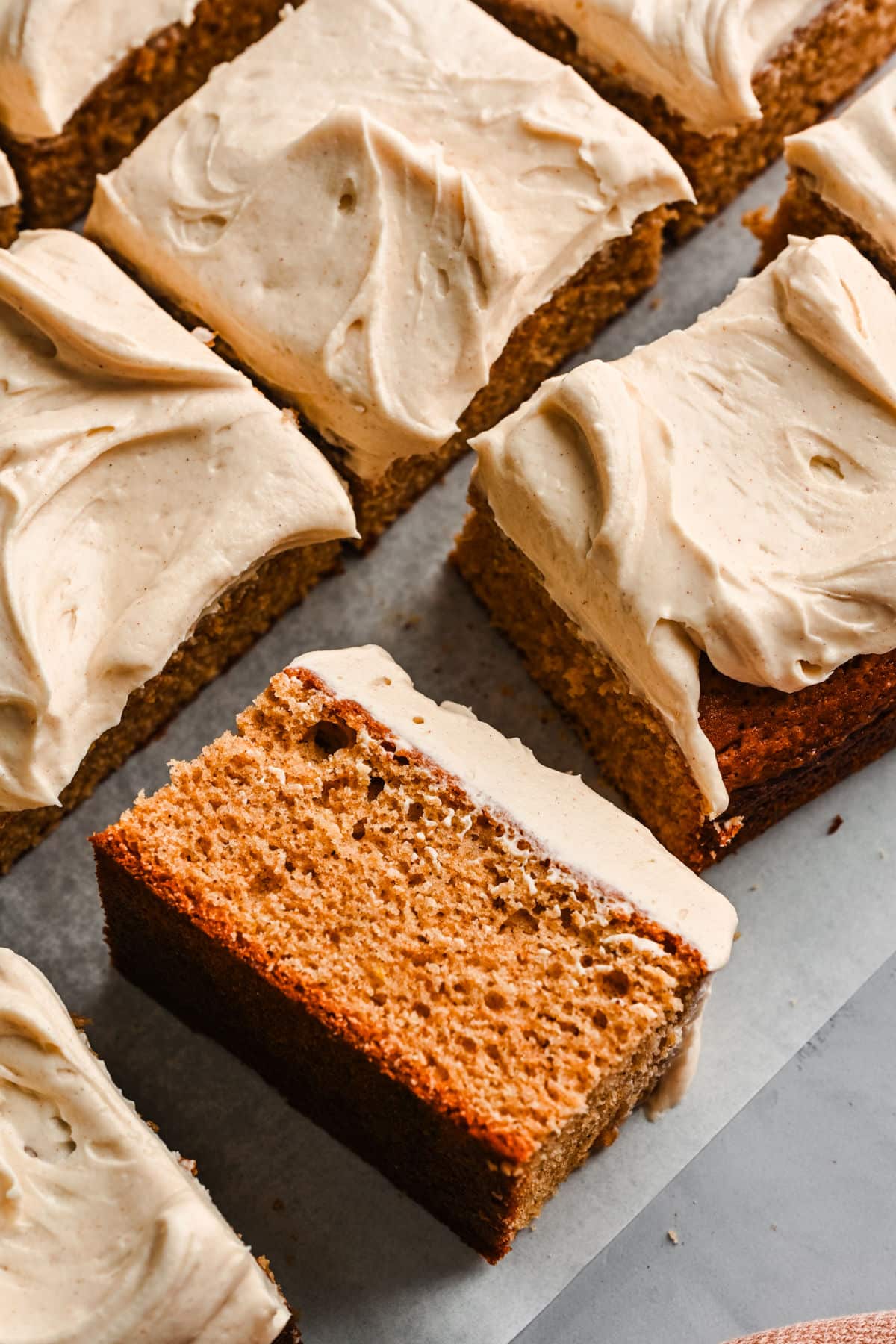 A slice of spice cake on its side next to the whole cake. 