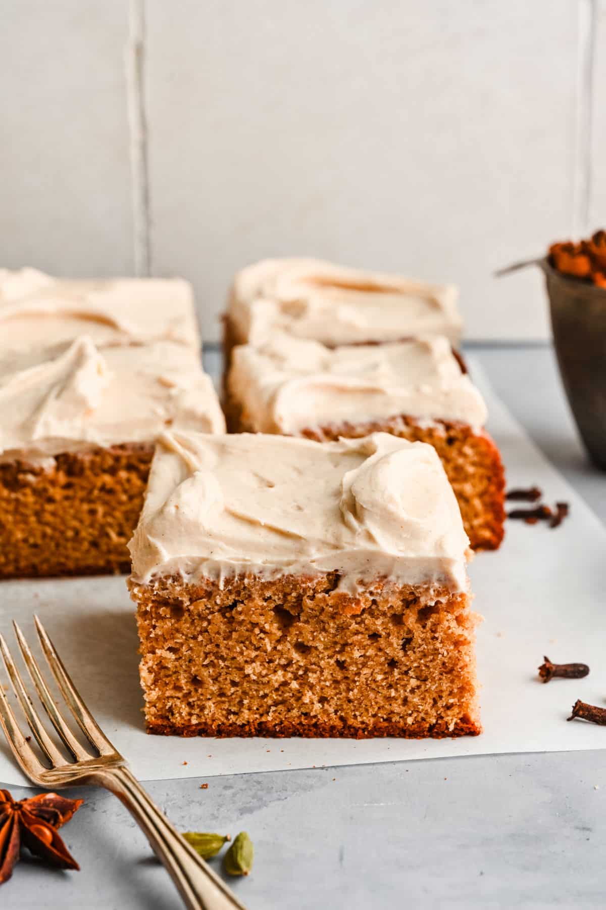 Slices of homemade spice cake on a piece of white parchment paper. 