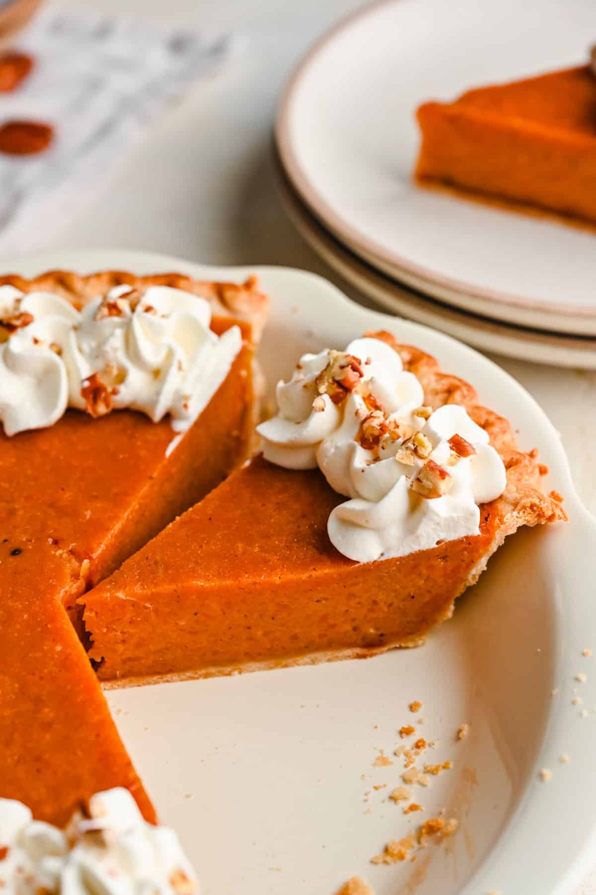 A slice of sweet potato pie next to the cut pie. 