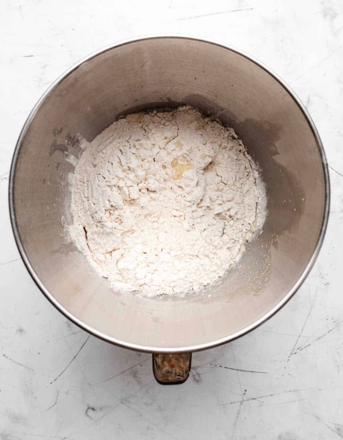 Flour mashed potatoes butter and sugar in a silver mixing bowl.