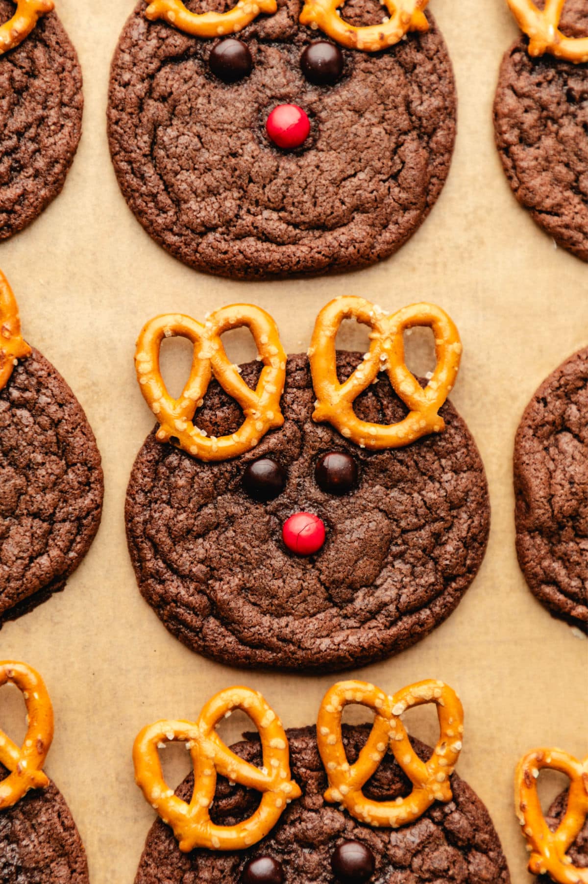 Rows of reindeer cookies on brown parchment paper.