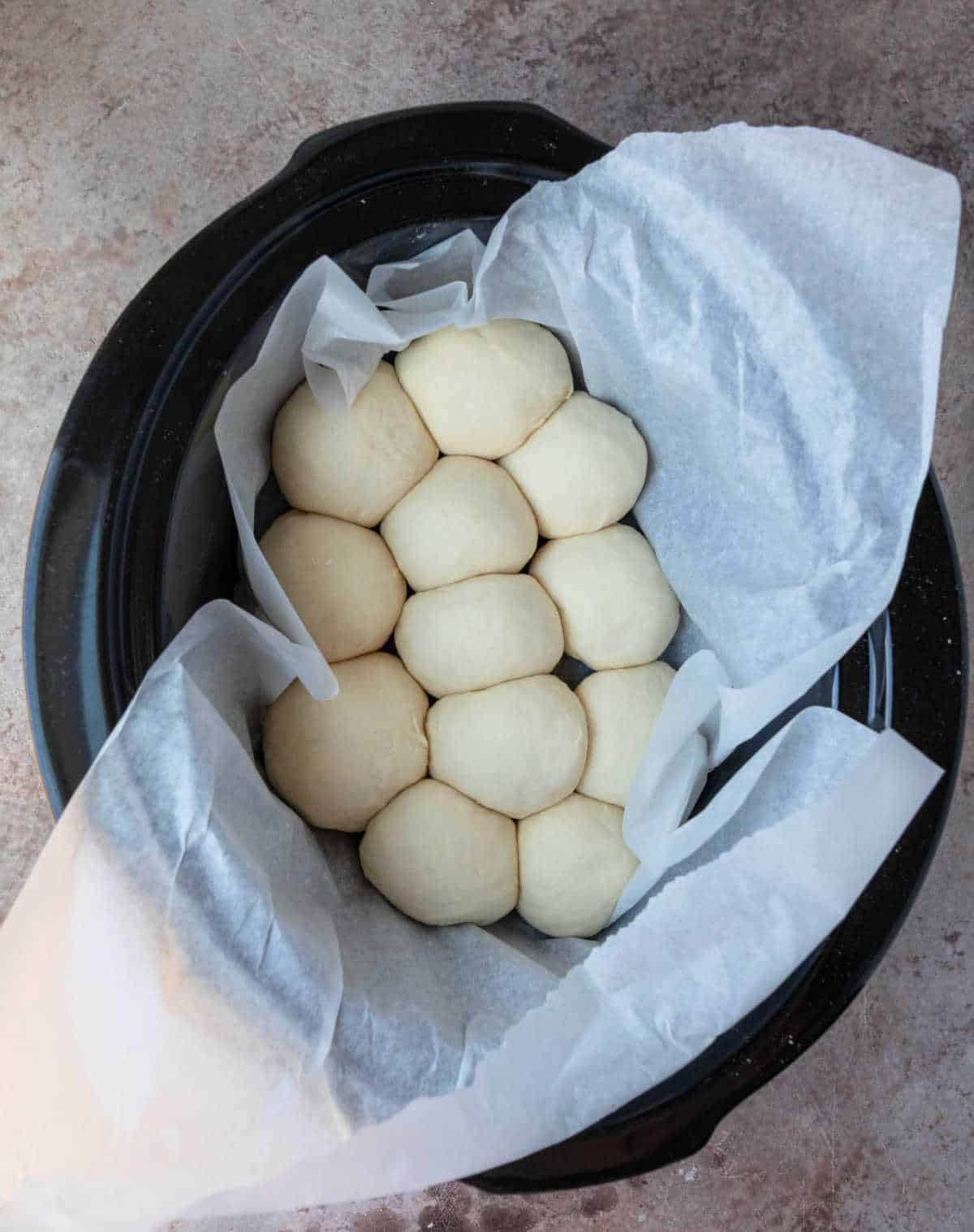 Risen slow cooker dinner rolls in a slow cooker. 