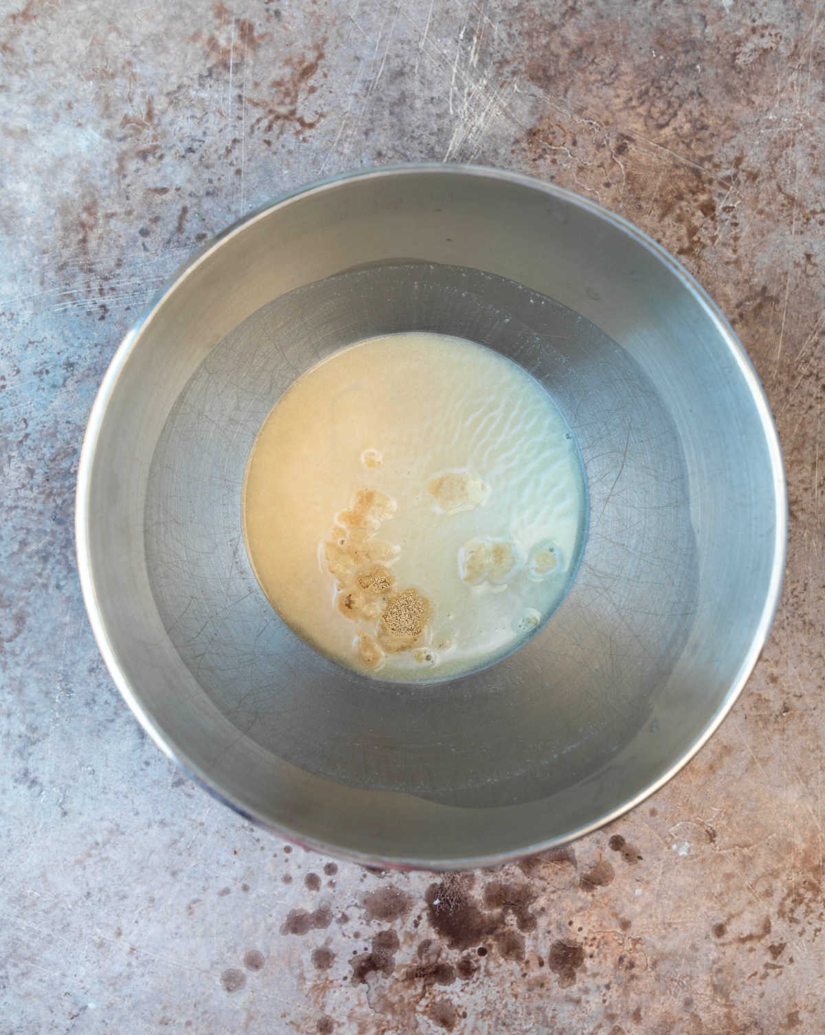 Yeast proofing in a silver mixing bowl. 