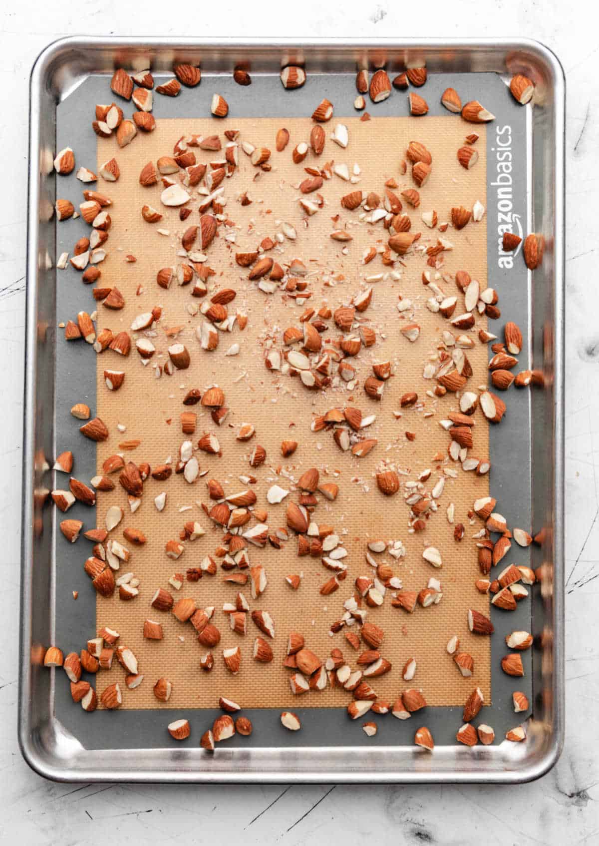 Chopped almonds sprinkled over a silicone baking mat.