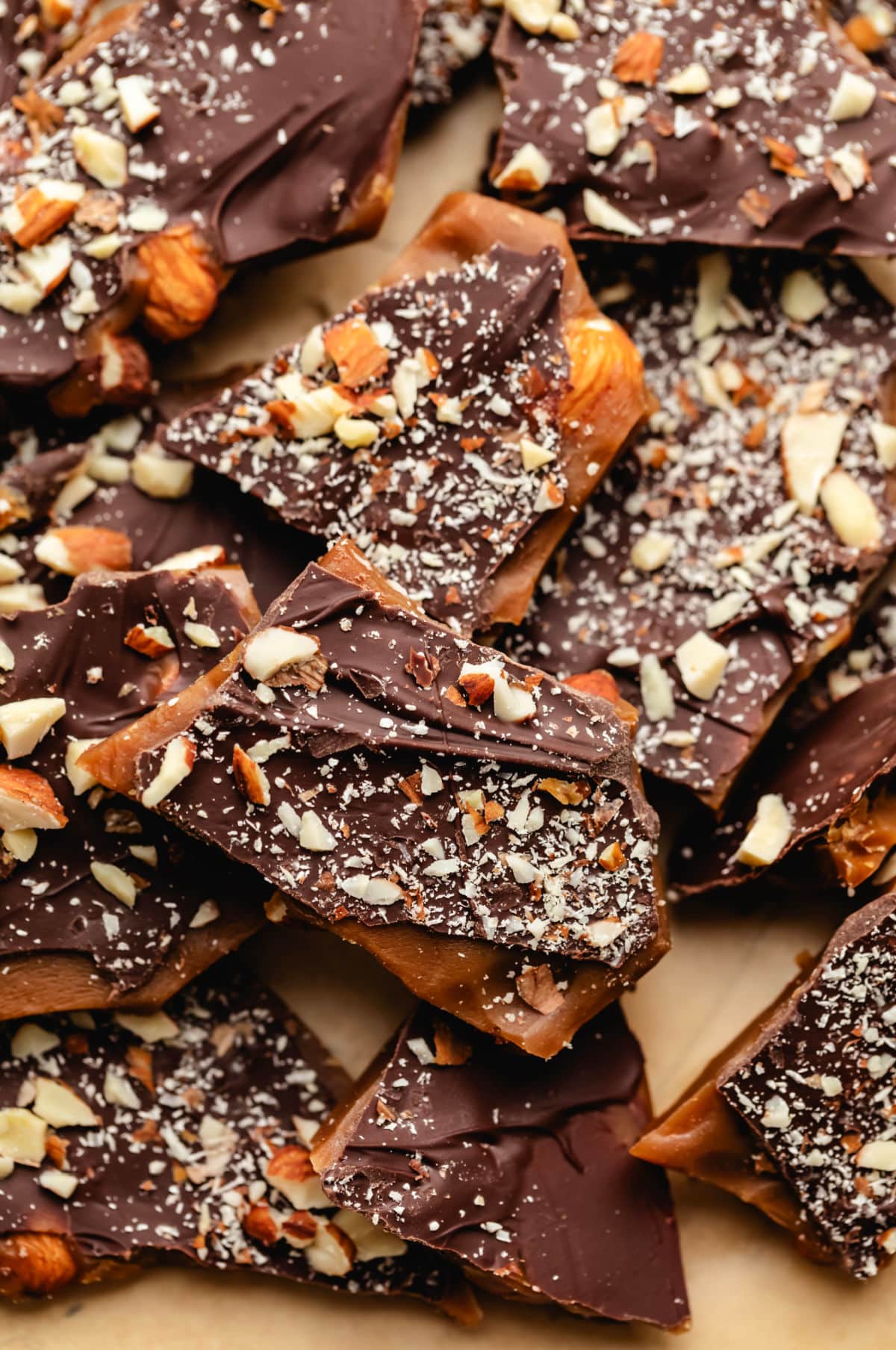 Pieces of homemade English toffee on brown parchment paper.