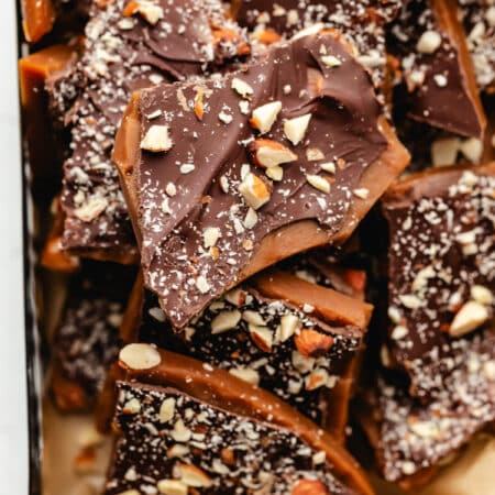 Pieces of homemade toffee in a black metal container.