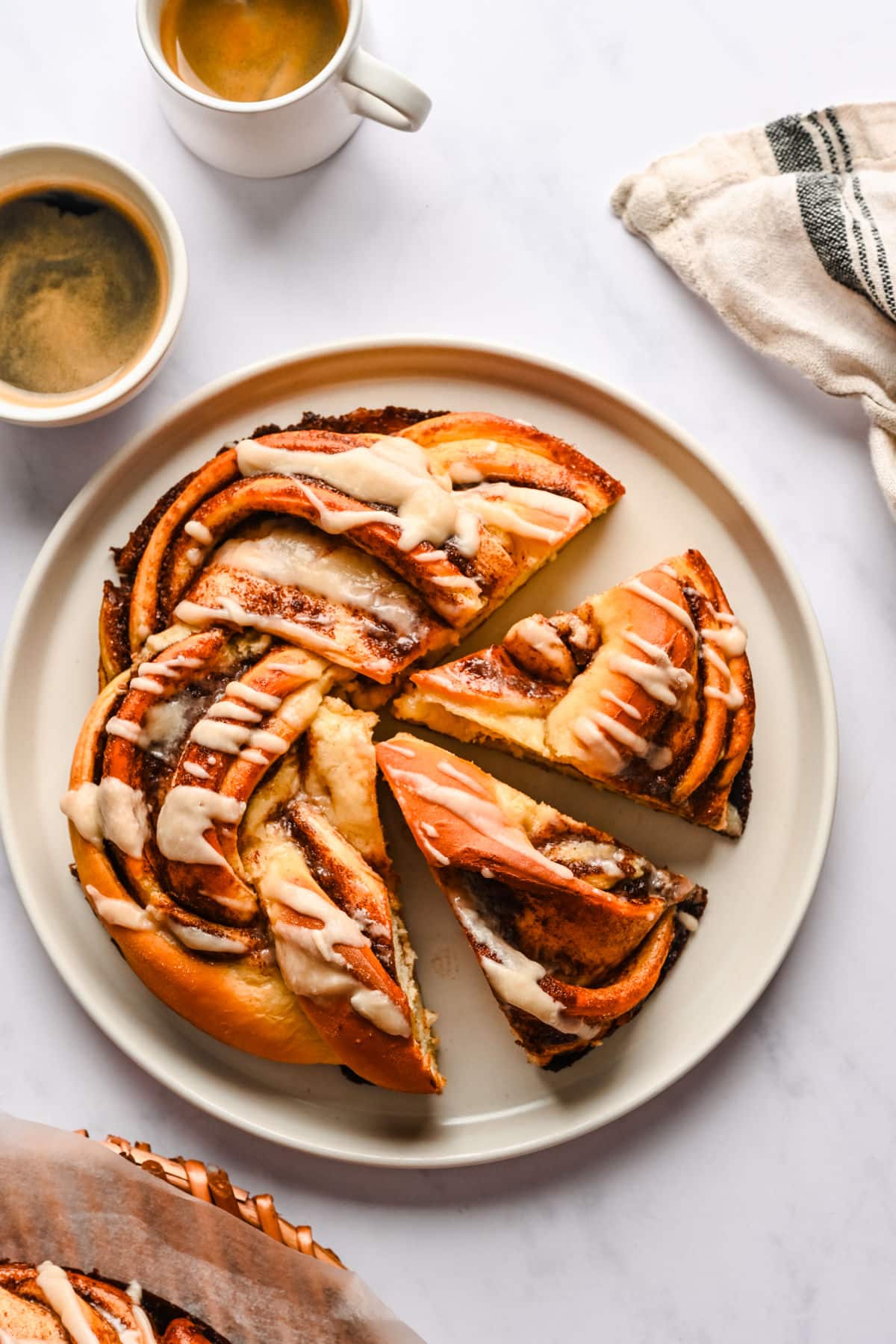 A loaf of braided cinnamon bread with two pieces cut.