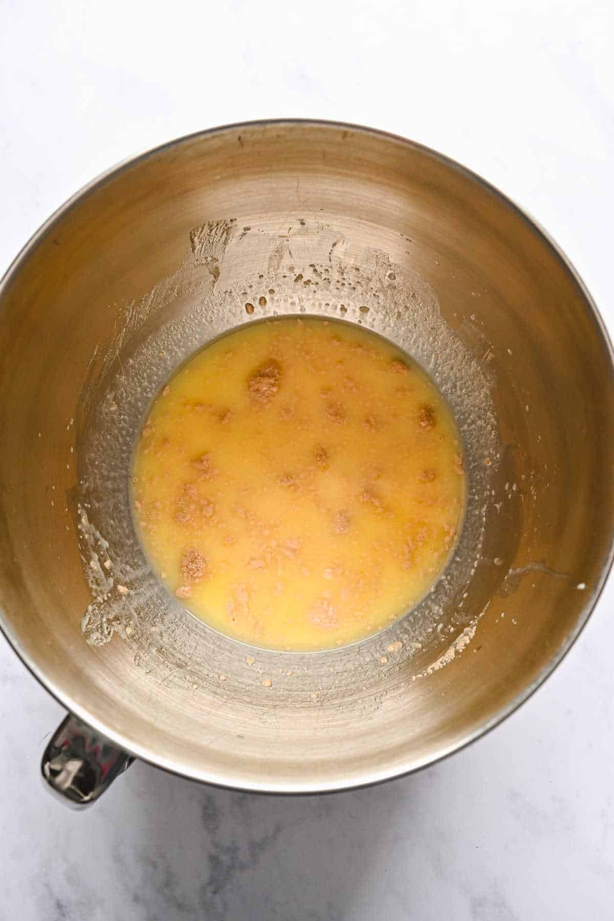 Yeast and butter mixture in a silver mixing bowl. 