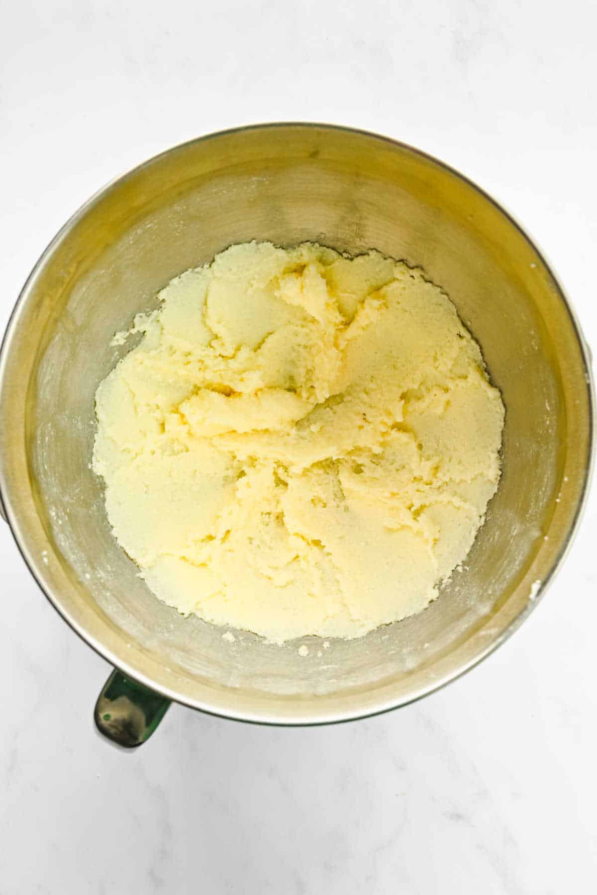 Creamed butter and sugar in a silver mixing bowl. 