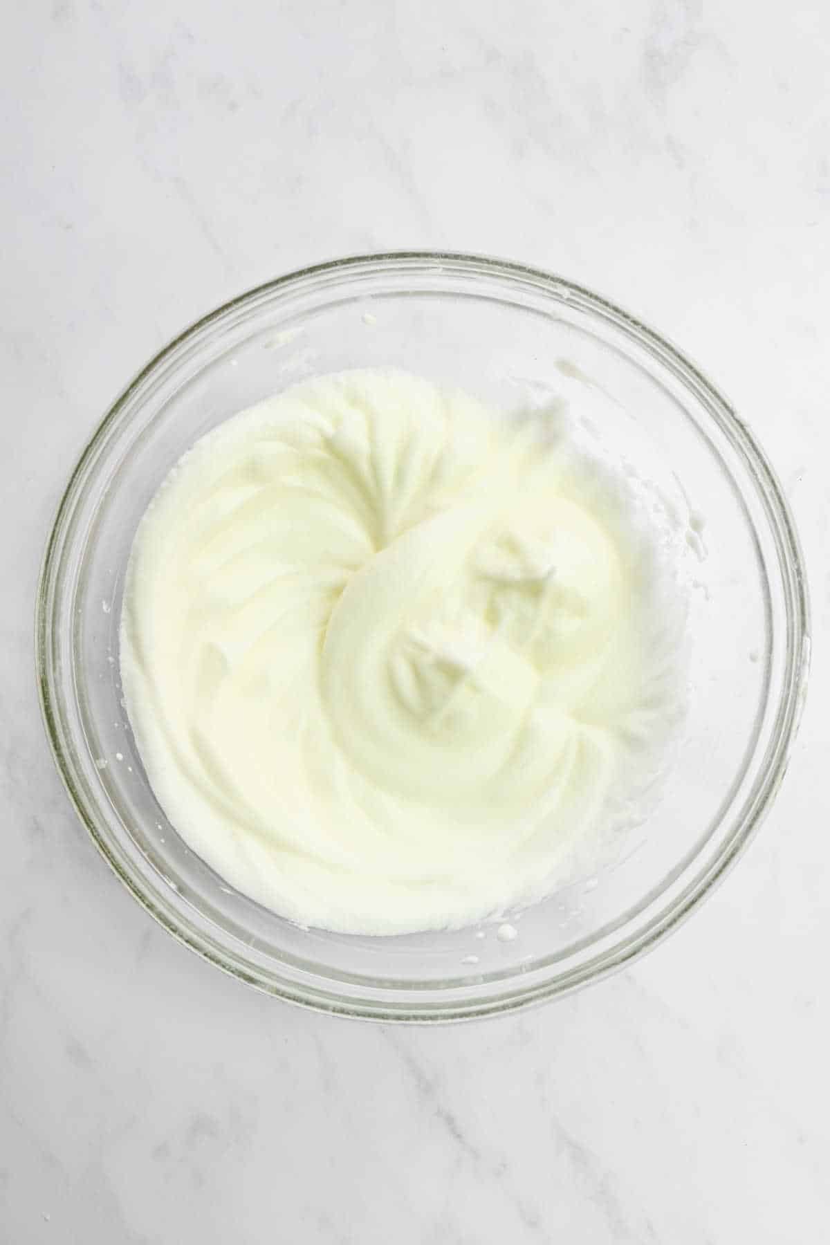 Melted white chocolate in a glass mixing bowl. 