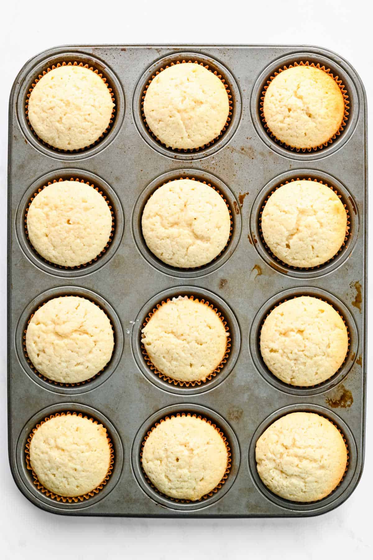 Baked white cupcakes for Christmas tree cupcakes in a muffin tin. 