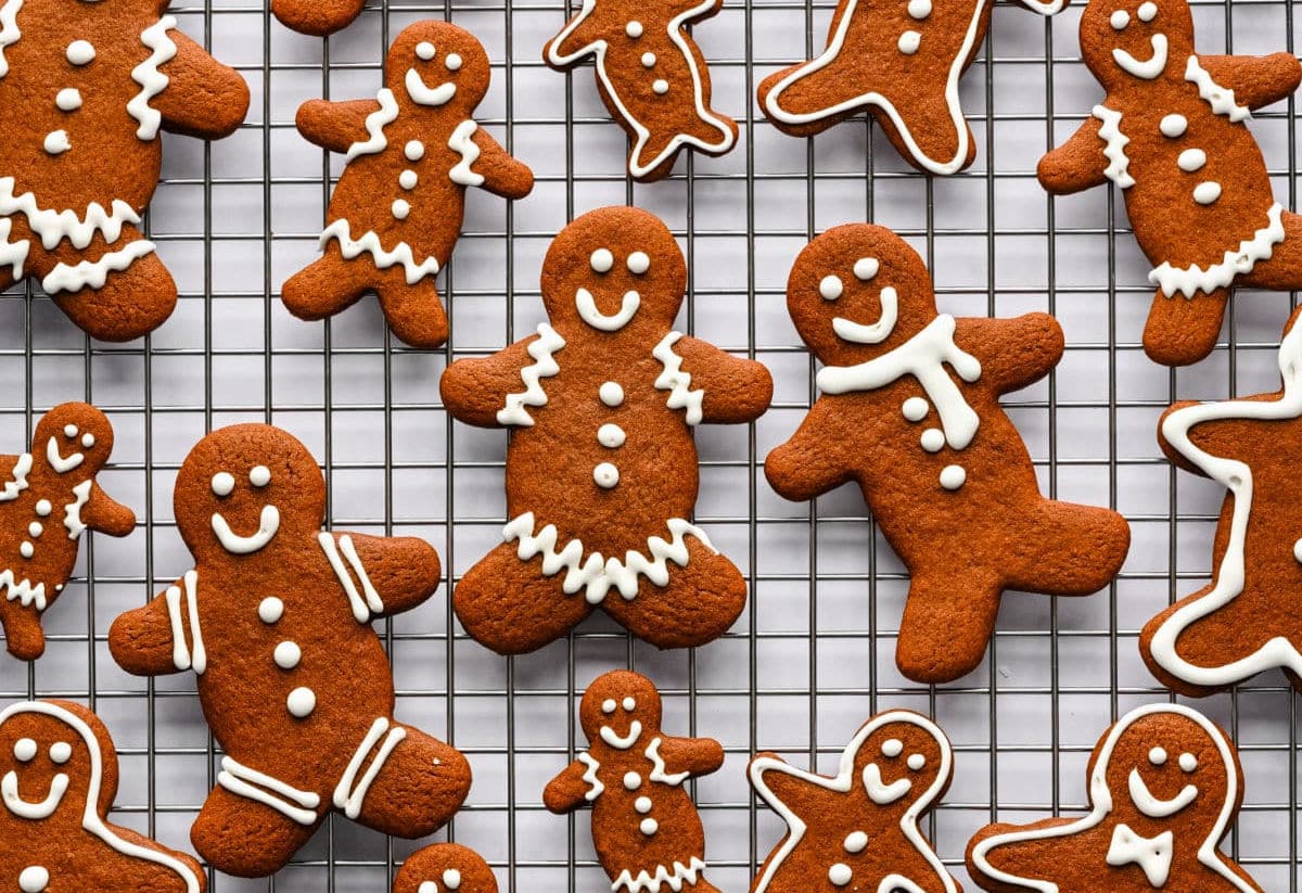 Decorated gingerbread men and women on a wire cooling rack.
