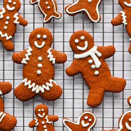 Decorated gingerbread men on a wire cooling rack.