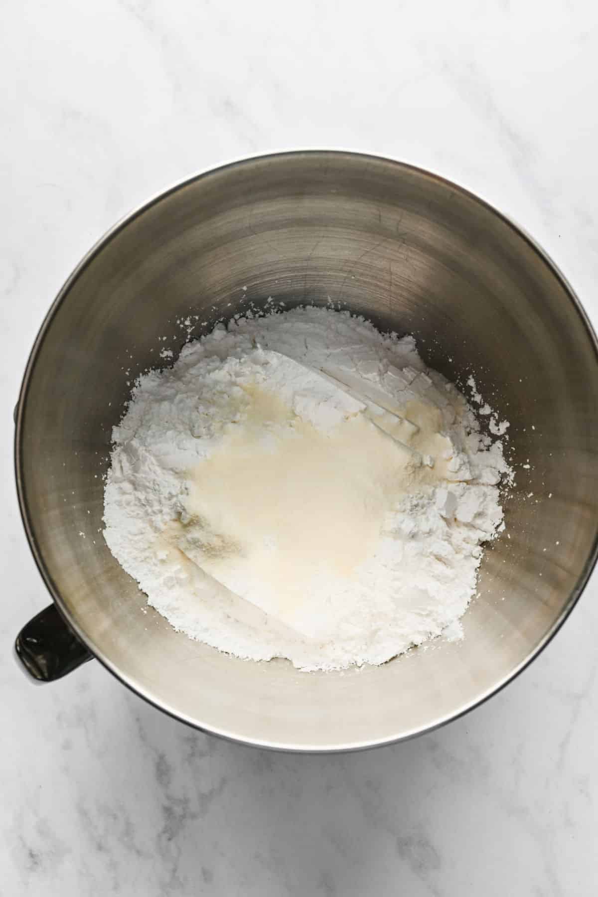 Powdered sugar and meringue powder in a silver mixing bowl. 