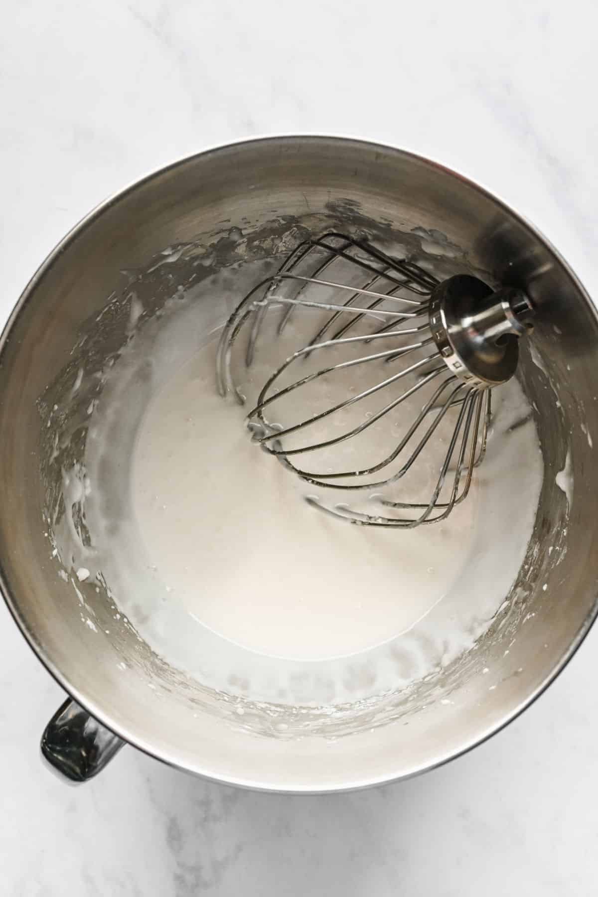 A wire wish attachment in a bowl of unbeaten royal icing.