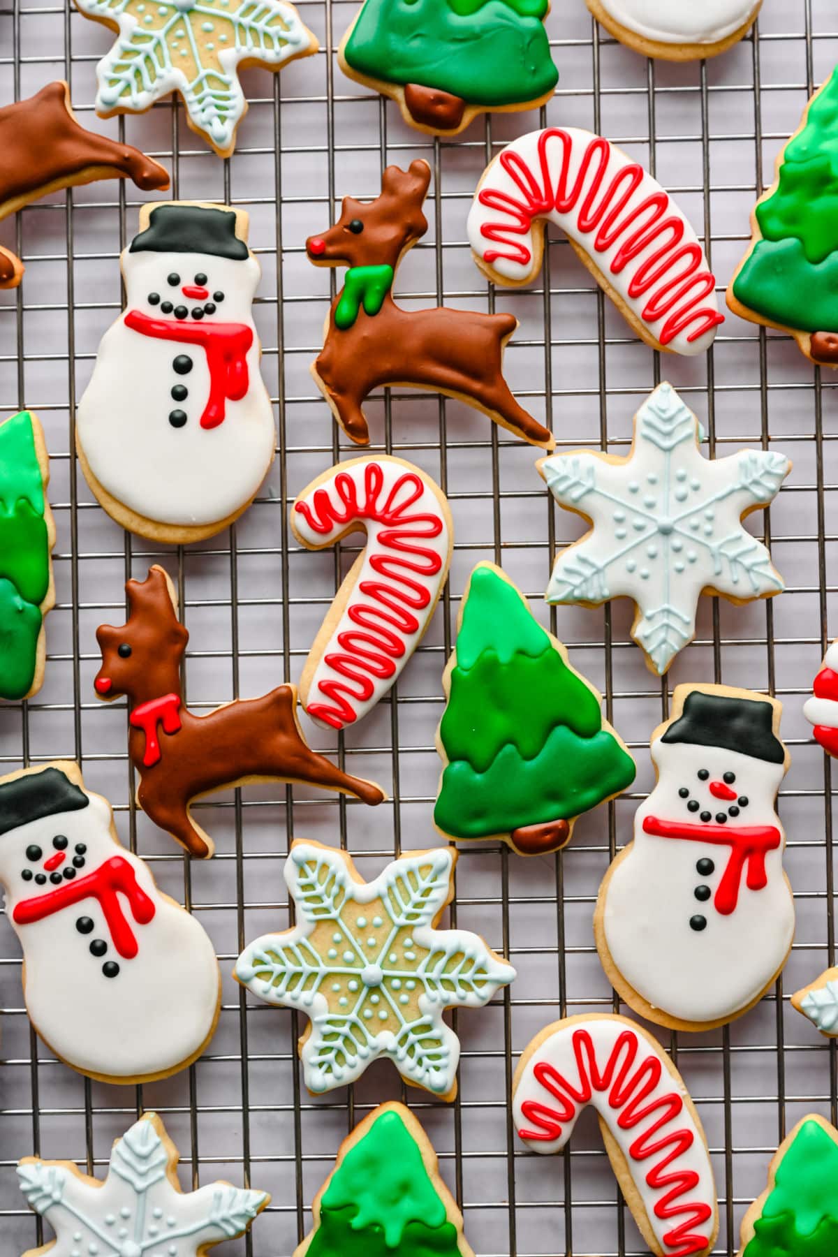 Cut out sugar cookies decorated with royal icing on a wire cooling rack. 