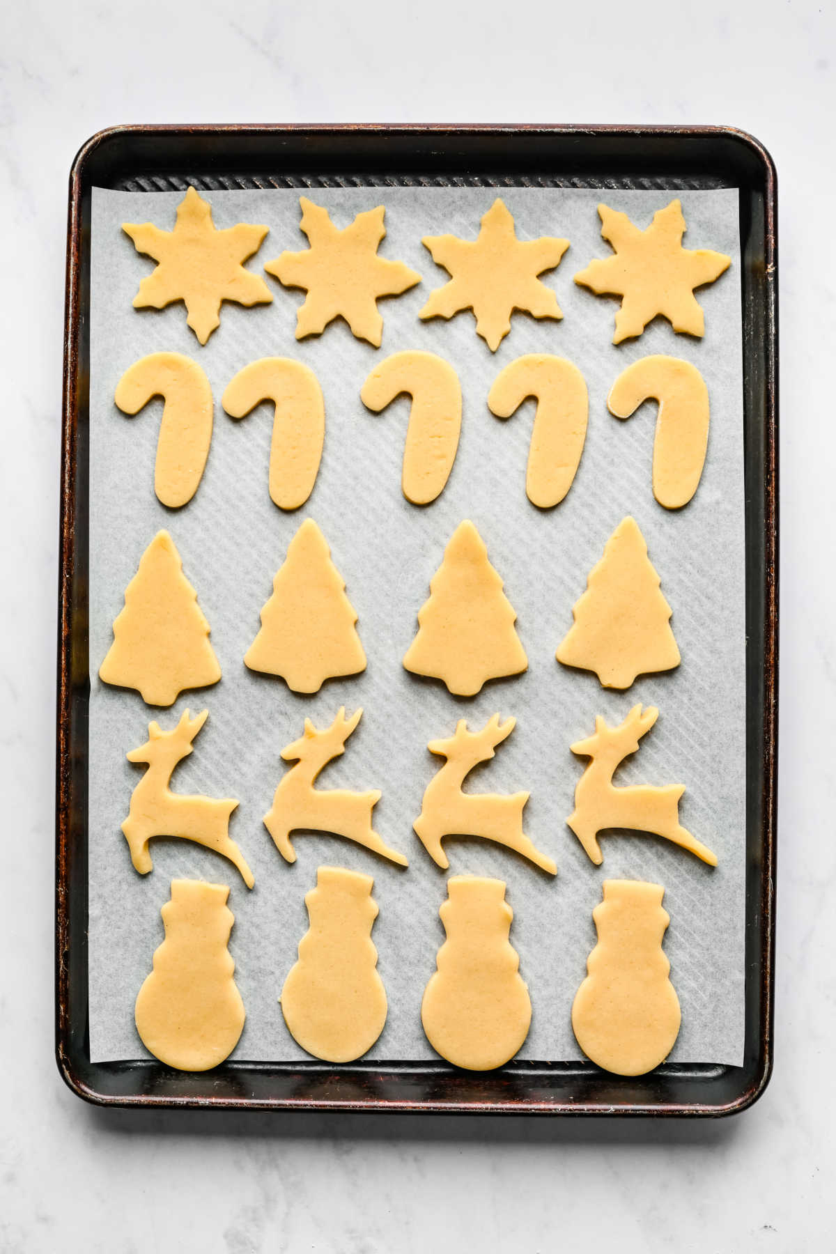 Cut out sugar cookie dough on a baking sheet. 