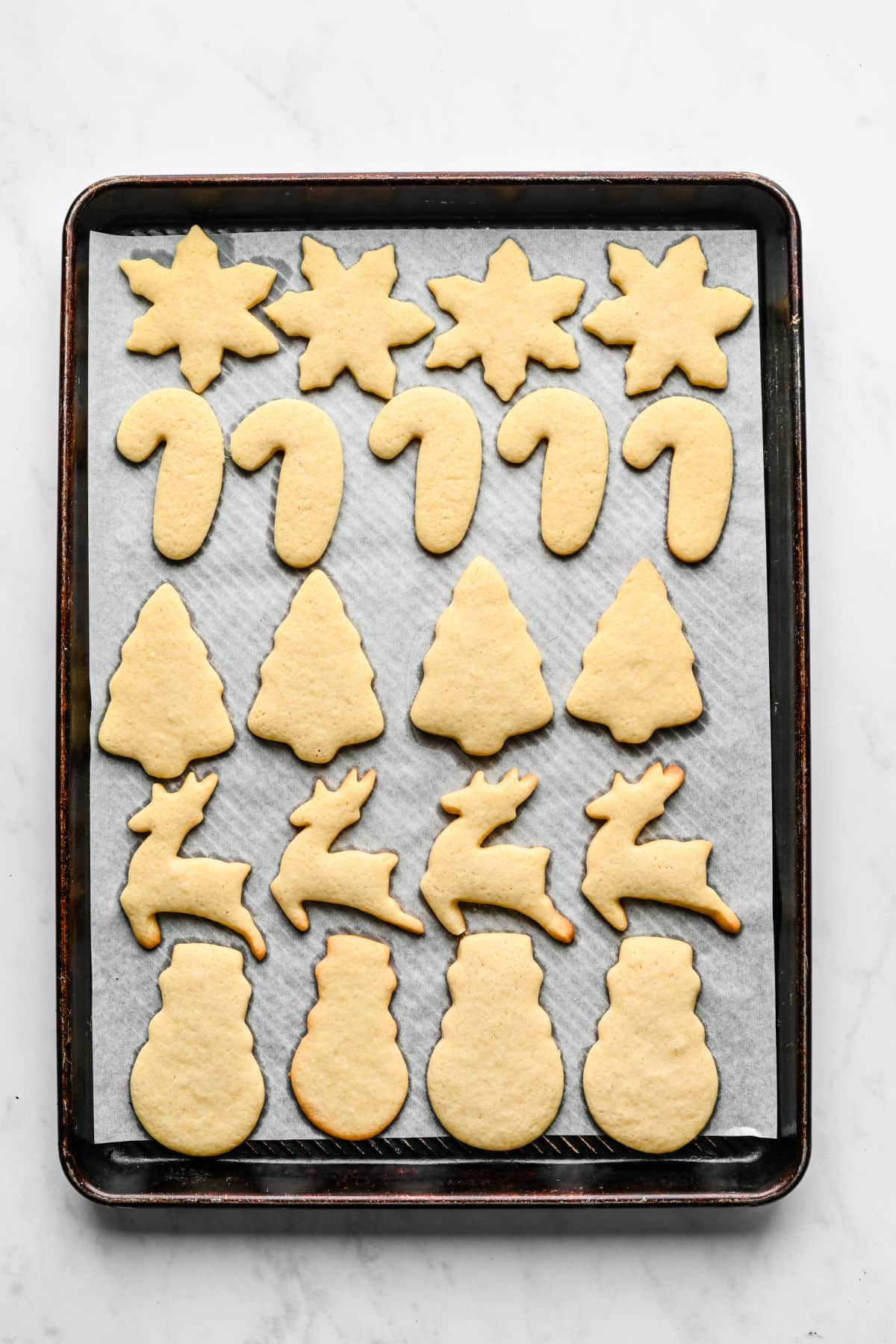 Baked cut out sugar cookies on a baking sheet. 