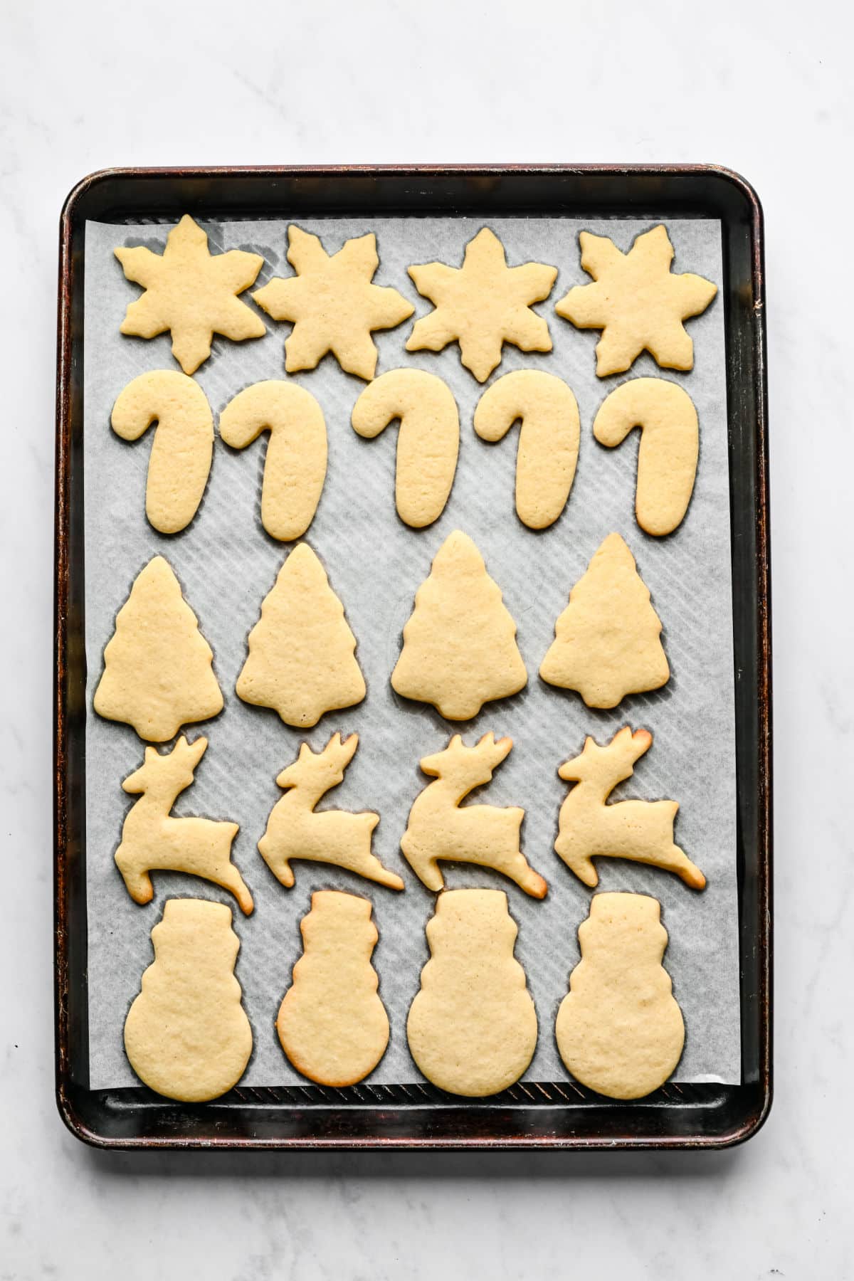 Baked cut out sugar cookies on a baking sheet.