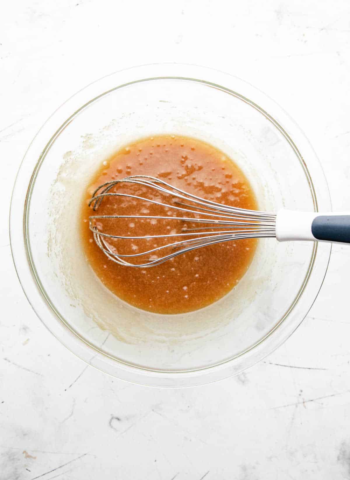 Egg whisked into melted butter and sugar mixture. 