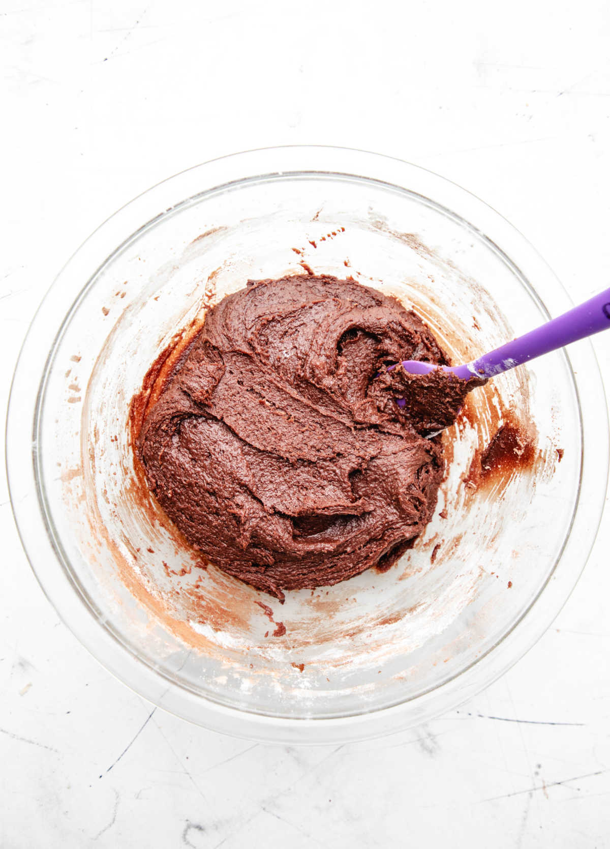 Chocolate cookie batter in a glass mixing bowl. 